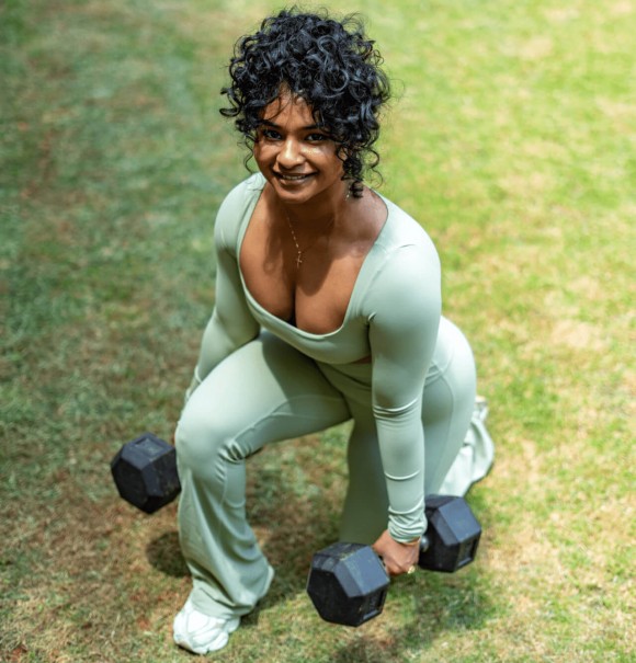 Manager of Sculpt by Christlene performing lunge exercises outdoors  with weights