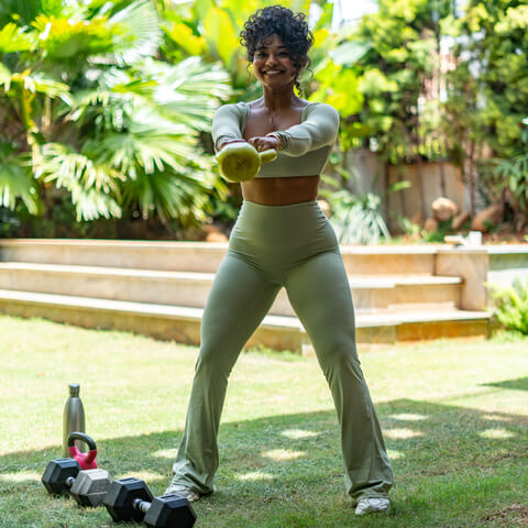 Manager of Sculpt by Christlene training outdoors using a dumbell showing a balanced burn for The PCOS Reset, Fat Loss Challenge