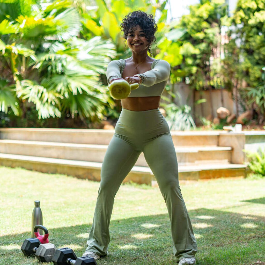 Manager of Sculpt by Christlene training outdoors using a dumbell showing a balanced burn for The PCOS Reset, Fat Loss Challenge