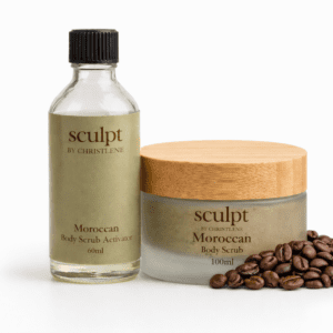 A bottle and jar of moroccan body scrub sitting next to cocoa beans with a white background available at Sculpt by Christlene